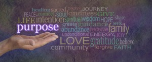 What is Life's Purpose - male hand open palm upwards with the word Purpose floating above surrounded by a multicolored word cloud on a wide stone effect background